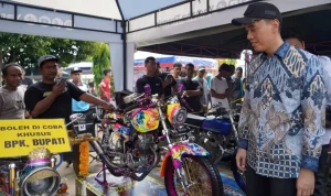 Bupati Kabupaten OKI, H. Muchendi Mahzareki, menyaksikan motor yang ditampilkan pada perlombaan Lempuing Motor Show pada kegiatan Lenterra Desa di Kecamatan Lempuing. (WARTADESAKU.CO.ID/WAHYUDI)